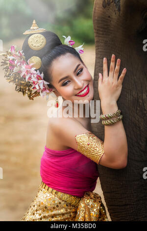 Bella ragazza tailandese nel tradizionale abito tailandese con elefante Foto Stock
