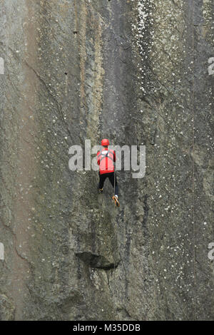 L'uomo la discesa in corda doppia giù una parete di roccia nella cava della Cattedrale, Little Langdale nel Lake District inglese, Cumbria, Regno Unito. Foto Stock