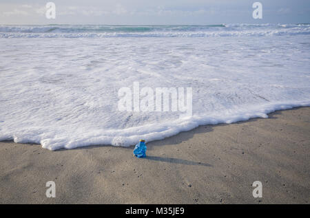 Uso singola bottiglia di plastica lavati fino in spiaggia Foto Stock