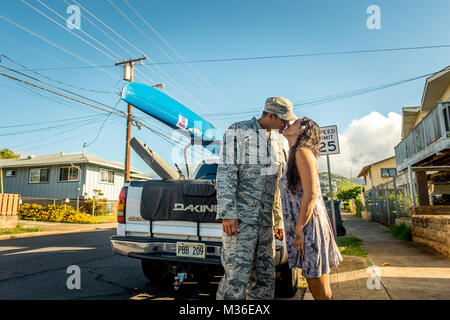 TSgt. Alfred Van Gieson, a sinistra un reservist con il 735th aria mobilità Squadron, bacia la moglie Jenny van Gieson, addio prima di dirigervi alla base comune a Pearl Harbor Hickam in Oahu, Hawaii, Agosto 13, 2016. Van Gieson è un veterano dell'Operazione Iraqi Freedom, un campione del mondo outrigger, o Va' a, paddler e pullman in sottovento Kai Canoa Club in Nanakuli, Oahu, che fu fondata dai suoi nonni. Sua moglie è campionessa di surf e stand up paddle-boarder. (U.S. Air Force foto di J.M. Eddins Jr.) 160813-F-LW859-012 da AirmanMagazine Foto Stock