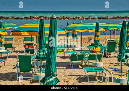 Vista rilassante del mare di fronte di ombrelloni e sedie a sdraio di uno stabilimento balneare sulla costa adriatica Foto Stock