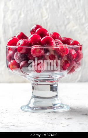 Bacche di colore rosso ciliegia congelato in coppa dessert Foto Stock