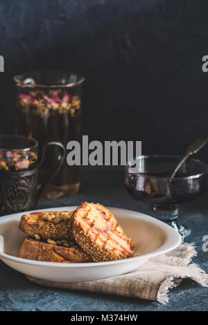 Crostini di pane con i semi di sesamo torta casalinga in pila decorate con pinoli sulla piastra bianca Foto Stock