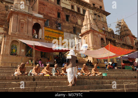 Holymen sedersi sui gradini di Varanasi, India Foto Stock
