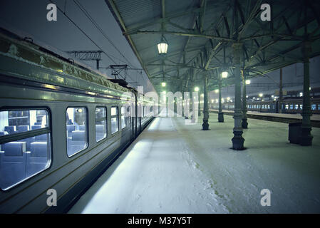 Vista notturna della stazione piattaforme a freddo nevoso inverno. Foto Stock
