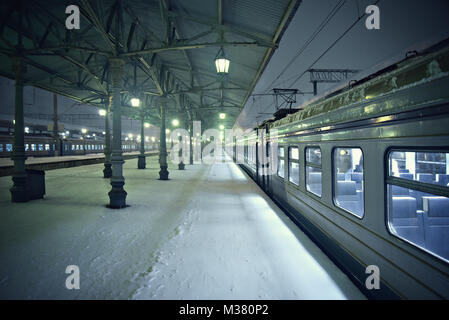 Vista notturna della stazione piattaforme a freddo nevoso inverno. Foto Stock