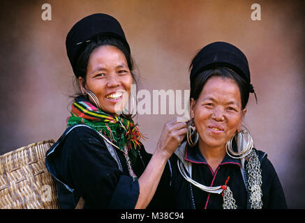 Il Vietnam. Sapa. Le donne di nero hilltribe Hmong disponendo un orecchino. Ritratto. Foto Stock