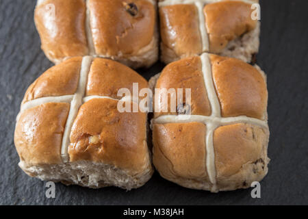 Quattro Easter hot cross panini su un livello di grigio ardesia Foto Stock