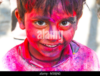 Un ragazzino coperto di vernice in polvere durante la celebrazione della primavera indù Holi festival in New Delhi, India. Foto Stock