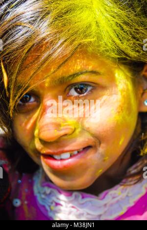 Una bambina coperto di vernice in polvere durante la celebrazione della primavera indù Holi festival in New Delhi, India. Foto Stock