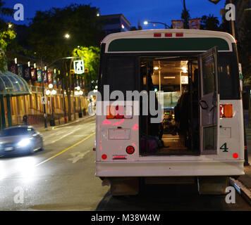 In attesa di Bus downtown dal retro di notte Foto Stock