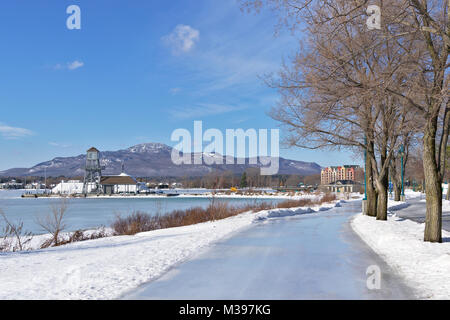 Inverno pattinaggio all'aperto con la montagna e lago ghiacciato in background - Pointe allegro, Magog Quebec en hiver Foto Stock