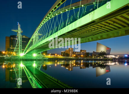 Lowry passerella e Imperial War Museum North di notte, Salford Quays, Greater Manchester, Inghilterra, Regno Unito Foto Stock