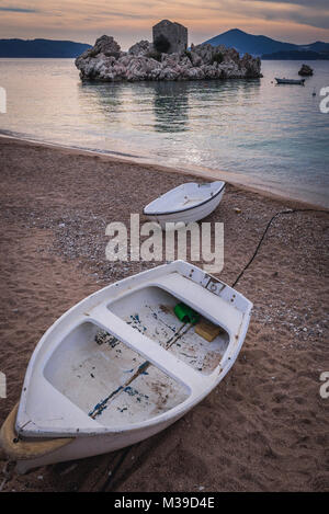 Piccola barca su una spiaggia in Przno resort villaggio sul mare Adriatico costa vicino a città di Budva Montenegro Foto Stock