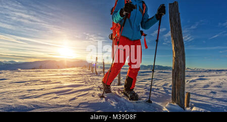 Primo piano dello snowboarder passeggiate con le racchette da neve in polvere di neve. Unione scenario alpino, sport invernali e attività Foto Stock