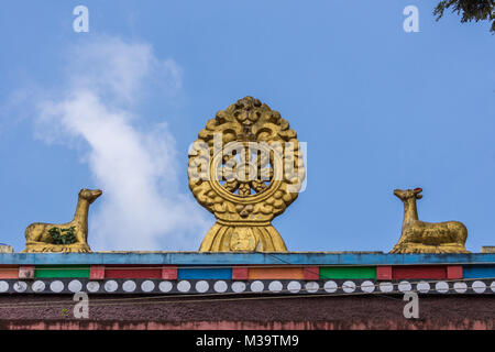 Coorg, India - 29 Ottobre 2013: Chakra e cervi statue sulla sommità del monaco e monaca quarters a Namdroling monastero buddista. Foto Stock