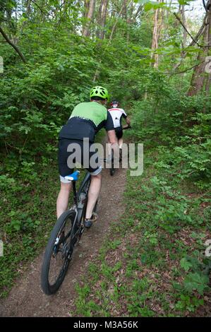 Escursioni in bicicletta attraverso i sentieri nei boschi Foto Stock