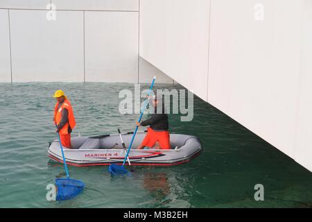 Paio di rifiuti marino pulitori raccoglie rifiuti dal mare con barca Foto Stock