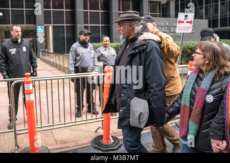 New York, Stati Uniti d'America, 10 feb 2018. Diritti degli immigrati attivista Ragbir Ravi e sua moglie Amy Gottlieb guardare poliziotti a guardia di una costruzione federale come essi partecipano in un "non riesci a deportare un movimento di protesta nella città di New York il 10 febbraio. Ragbir era stato concesso il soggiorno temporaneo di deportazione il giorno prima della sua rimozione pianificata. Foto di Enrique Shore/Alamy Live News Foto Stock