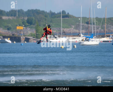 Helsinki, Finlandia - 9 Giugno 2017: finlandese non identificato Coast Guard rescue nuotatore scende giù per il Mar Baltico da un filo in esercitazione di soccorso o performa Foto Stock