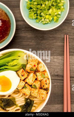 In stile giapponese tofu vegetariani Noodle Ramen zuppa o brodo al buio su un tavolo di legno Top Foto Stock