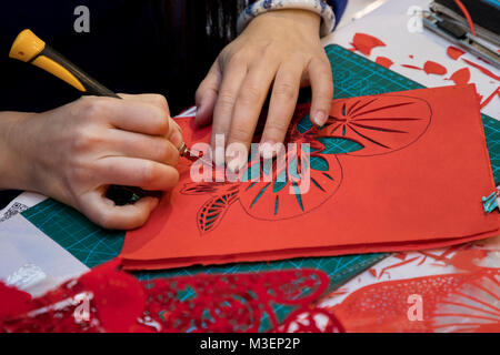 Un maestro cinese è impegnato in Jianzhi folk art - folk tradizionale cinese decorativo il taglio della carta Foto Stock