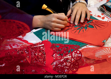 Un maestro cinese è impegnato in Jianzhi folk art - folk tradizionale cinese decorativo il taglio della carta Foto Stock