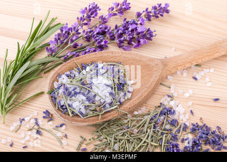 Il cucchiaio di legno con sale alle erbe aromatiche di rosmarino e lavanda fiori Foto Stock