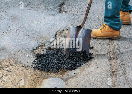 La costruzione di strade. Il nuovo asfalto, cemento cordolo in calcestruzzo di colore arancione e barriere di sicurezza sulla strada. Foto Stock