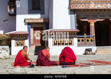 Phobjikha, Bhutan. I monaci buddisti seduto nel cortile del monastero Gangte Goemba (). Foto Stock