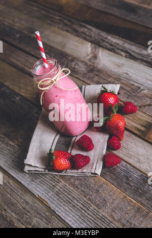 Bicchiere di deliziosi berry smoothie su sfondo di legno. Vista laterale. Foto Stock