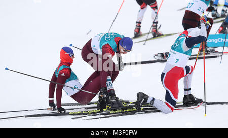 Eventuale vincitore Simen Hegstad Krueger della Norvegia si blocca con Andrey Larkov e Denis Spitsov di Remo durante l'avvio del Mens 15km + 15km Skiathlon al Alpensia Centro Sci Fondo durante il giorno due di PyeongChang 2018 Giochi Olimpici Invernali in Corea del Sud. Foto Stock