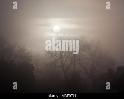 Il sole cercando di rompere attraverso la nebbia in Woldingham village , Woldingham Surrey, Regno Unito Foto Stock