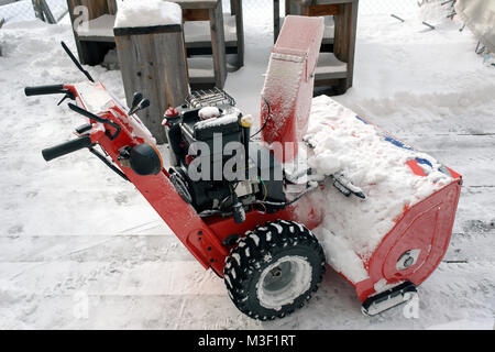 Un manuale di spazzaneve o neve macchina per la pulizia delle Alpi della Svizzera in un hotel giardino Foto Stock