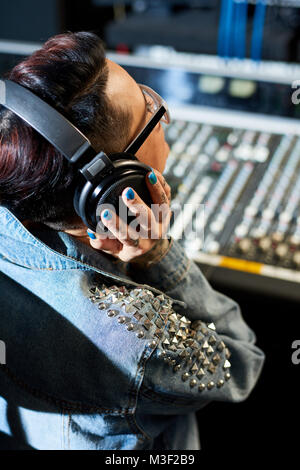 Produttore ascoltando la traccia audio in studio Foto Stock