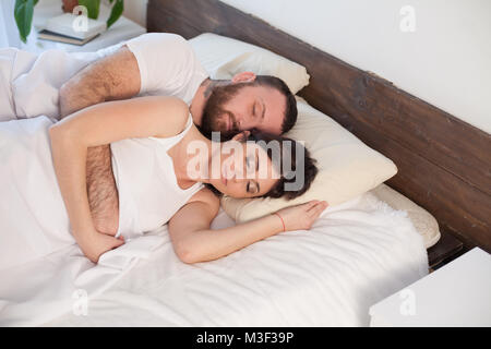 Un uomo e una donna che dorme in letti a casa Foto stock - Alamy