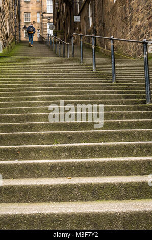 Uomo che cammina fino ripide scale di pietra in un vicolo o stretto passaggio, Warriston vicino, Cockburn Street, Edimburgo, Scozia, Regno Unito Foto Stock