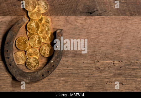 Pila di monete d'oro che fluisce nel ferro di cavallo per il giorno di San Patrizio Foto Stock