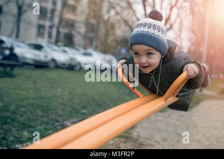 Divertirsi nel campo giochi / Autunno foto circa il ragazzo con bilanciamento del bianco personalizzato, filtri di colore ed effetto vignetta. Foto Stock