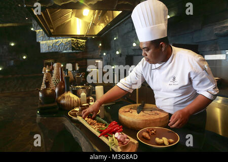 Uno chef che prepara cucina indonesiana nella sua cucina in The Ritz-Carlton Bali hotel resort.Nusa Dua. Bali .Indonesia Foto Stock