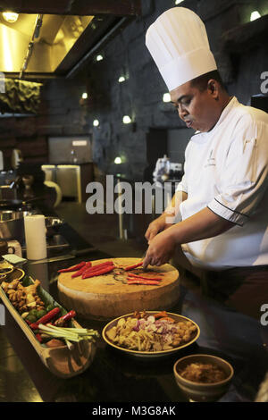 Uno chef che prepara cucina indonesiana nella sua cucina in The Ritz-Carlton Bali hotel resort.Nusa Dua. Bali .Indonesia Foto Stock