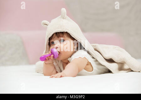 Ritratto di bambina giocando con il giocattolo sul coperta a casa Foto Stock