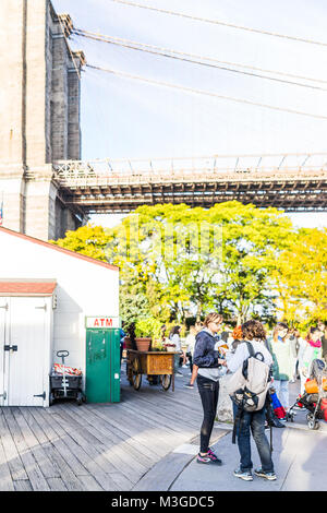 Brooklyn, Stati Uniti d'America - 28 Ottobre 2017: fuori all'aperto in NYC New York City Ponte di Brooklyn Park con molti folla di persone sulla passerella di legno dal segno atm Foto Stock