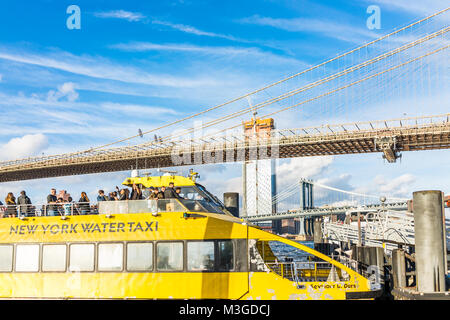 Brooklyn, Stati Uniti d'America - 28 Ottobre 2017: fuori all'aperto in NYC New York City Ponte di Brooklyn Park con molti folla di persone sul water taxi giallo crui traghetto Foto Stock