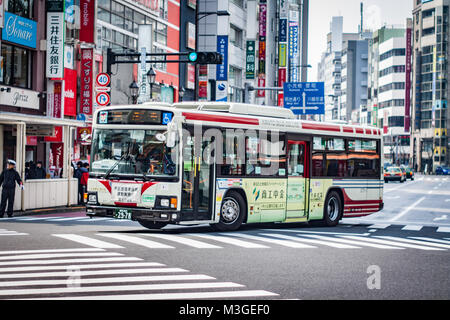 Bus giapponese guida attraverso un incrocio di Tokyo Foto Stock