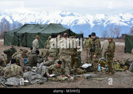 Stati Uniti Paracadutisti dell'esercito assegnata al 1° Battaglione, 503rd Reggimento di Fanteria, 173rd Brigata Aerea, esercito italiano paracadutisti dalla Brigata Julia Alpini Paracadutisti e la Brigata Folgore e sloveno soldati dell esercito di rilassarsi dopo una navigazione terrestre evento durante il giro di collaudo per il fante esperto Badge. I soldati devono completare un numero di prerequisiti e passare a una batteria di test classificato sulla base delle competenze di fanteria, 6 febbraio 2018 a Cellina Meduna area, Pordenone, Italia. (U.S. Esercito Foto Stock