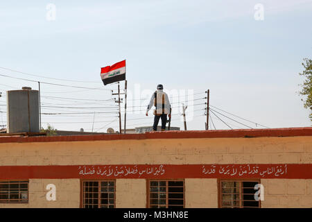 Un iracheno polizia federale officer fornisce la sicurezza per gli studenti di una scuola primaria in Aski Mosul, Iraq, nov. 13, 2017. L ampiezza e la diversità dei partner della coalizione dimostra il livello globale e unified obiettivo di sconfiggere ISIS in Iraq e la Siria. CJTF-funzione OIR è la coalizione globale per sconfiggere ISIS in Iraq e la Siria. (U.S. Esercito Foto Stock