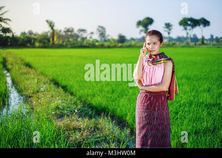 Bel contadino donna pensando in campo di riso, Thailandia Foto Stock