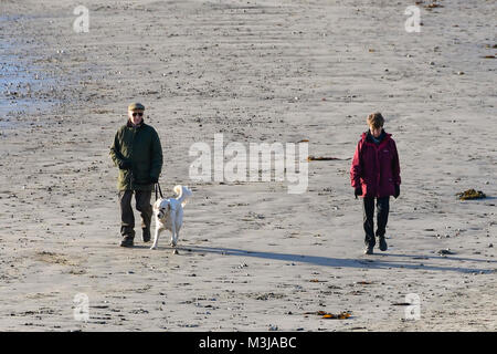 Lyme Regis, Dorset, Regno Unito. Xi Febbraio 2018. Regno Unito Meteo. Dog walkers sulla spiaggia godendosi il cielo sereno su una mattina di sole a Lyme Regis nel Dorset durante la scuola half term holidays. Credito Foto: Graham Hunt/Alamy Live News. Foto Stock