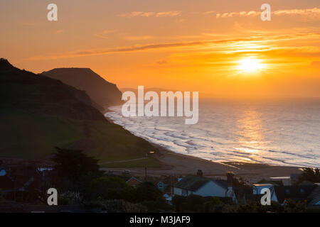 Charmouth, Dorset, Regno Unito. Xi Febbraio 2018. Regno Unito Meteo. Una spettacolare alba visto da Charmouth su Jurassic Coast di Dorset guardando verso il Golden Cap. Credito Foto: Graham Hunt/Alamy Live News. Foto Stock